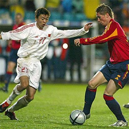 Fernando Torres intenta escapar del jugador chino Yonghai.