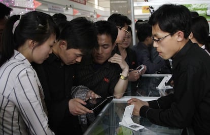 También hay una fuerte evidencia de que Corea del Norte permite a las personas involucradas en el pirateo informático o las operaciones cibernéticas el acceso necesario para un compromiso profundo con los ciberataques y el cibercrimen. En la foto, varias personas observan la tableta Samjiyon producida para el mercado de Corea del Norte en venta en la 16ª Feria Internacional de Primavera de Pyongyang, el 15 de mayo de 2013.