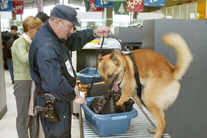 Un agente y un perro polica revisan equipajes en el aeropuerto de Roissy, en diciembre de 2001.