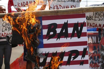 Manifestantes han acampado en protesta frente al Palacio Presidencial durante días en Manila (Filipinas) y queman una pancarta con la bandera norteamericana en la que dice 'Prohibir a Trump', el 7 de noviembre de 2017.