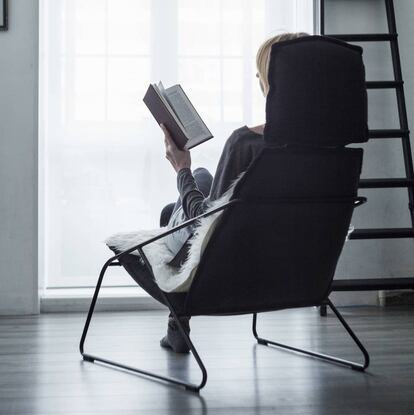Persona leyendo sentada en un sillón.