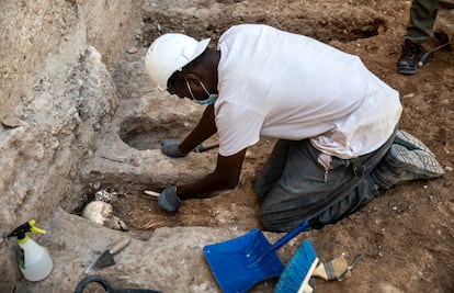 Un operario rescata los restos humanos hallados a los pies de la muralla árabe de Valencia.