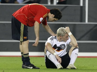 El jugador alemán Bastian Schweinsteiger es consolado por el español Cesc Fabregas.