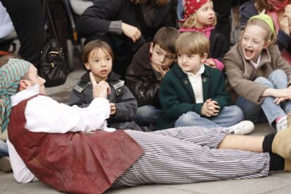 Un grupo de niños asiste a una obra de teatro en la calle de Fuencarral.