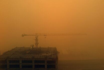 Obreros trabajan bajo una tormenta de arena en Dubái (EAU). La tormenta de arena y polvo, bautizada como la 'Tormenta Oscura', ha provocado la interrupción del tráfico aéreo en EAU y serios problemas de visibilidad en otros países del Golfo.