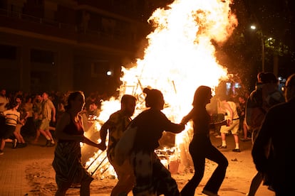 Decenas de personas bailan alrededor de una hoguera en el barrio de El Clot, en Barcelona.