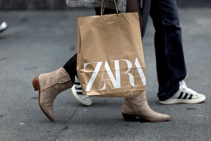 Una mujer transporta una bolsa de Zara, marca del grupo Inditex, en Bilbao.