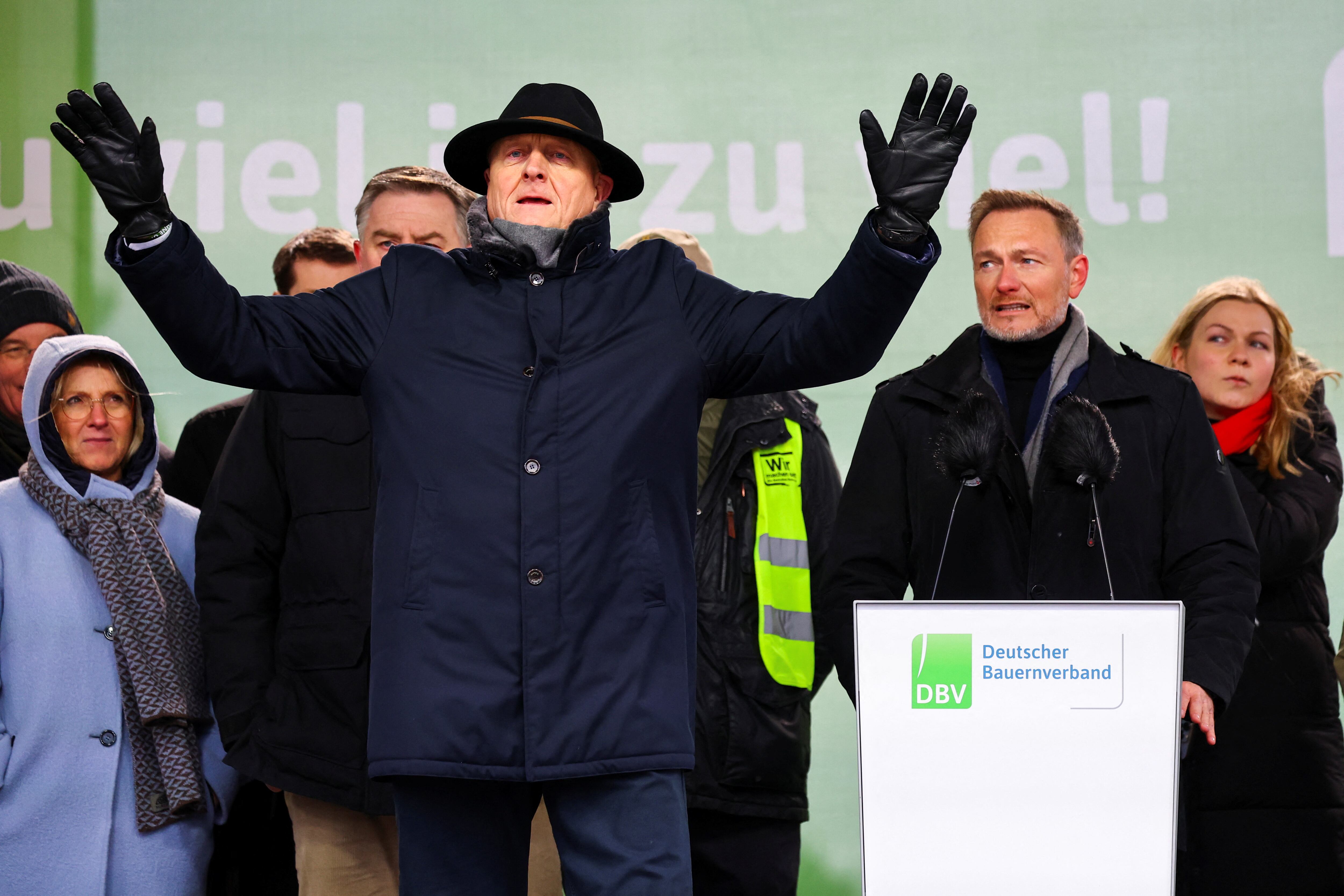 Joachim Rukwied, presidente de la asociación alemana de productores agrícolas, pide calma a los manifestantes para que pueda hablar el ministro de Finanzas, Christian Lindner, este lunes en Berlín. 