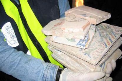Un policía muestra varias piezas arqueológicas requisadas en la Operación Lirio.