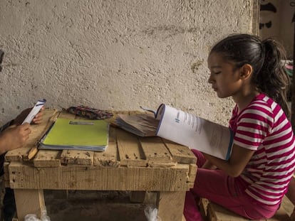 Justin, de 11 años, y Melani, de ocho, hijos de Delmi Judith Muralles Rodríguez, de 30 años, hacen los deberes en su casa en Potrero Grande (Guatemala) siguiendo las pautas didácticas recibidas poco antes del Ministerio de Educación.