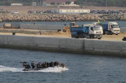 Una z&oacute;diac militar pasa frente a las obras del nuevo muelle en la base naval de Rota (C&aacute;diz).