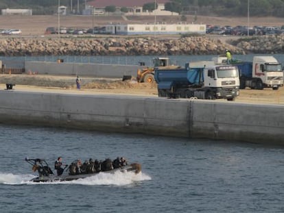 Una zódiac militar pasa frente a las obras del nuevo muelle en la base naval de Rota (Cádiz).
