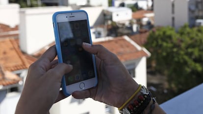 Una mujer mira a su tel&eacute;fono m&oacute;vil. 