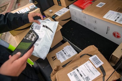 Un repartidor prepara pedidos de Amazon en su coche frente al centro logístico de Amazon de Alcobendas (Madrid).