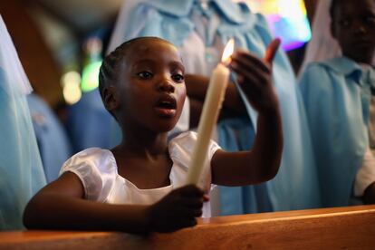 Una niña sostiene una vela durante el servicio del domingo de oración por Nelson Mandela en la Iglesia Ragina Mundi en Soweto, Sudáfrica.