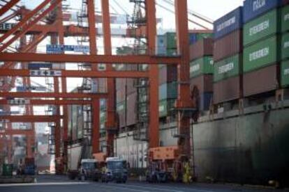 Fotografía de archivo del 12 de noviembre de 2012 donde se ve la carga de contenedores en el puerto de Tokio (Japón). Según los datos publicados hoy por el gobierno, el producto interno bruto de Japón (PIB) se contrajo un 0,4 por ciento en el periodo octubre-diciembre para el tercer trimestre consecutivo después de las exportaciones lentas.