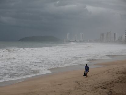 Un hombre camina este martes en una playa de Mazatlán, en Sinaloa, cerrada ante la inminente llegada del ciclón tropical Pamela.