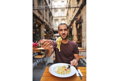 Un joven come un plato de tagliatelle en un restaurante romano.