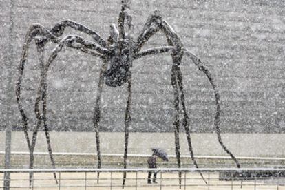 Una persona se protege de la nevada caída ayer cerca del Guggenheim de Bilbao.