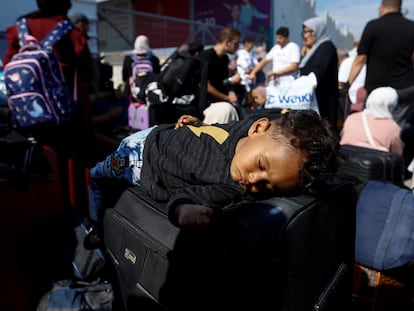 A child sleeps as Palestinians with dual citizenship gather outside Rafah border crossing with Egypt in the hope of getting permission to leave Gaza, amid the ongoing Israeli-Palestinian conflict, in Rafah in the southern Gaza Strip October 16, 2023. REUTERS/Ibraheem Abu Mustafa