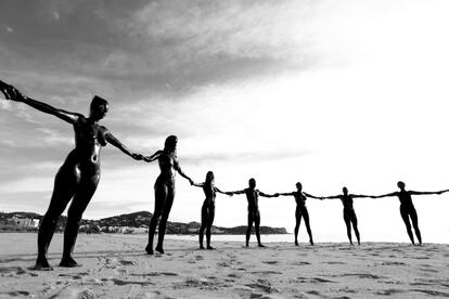 Un grupo de activistas, desnudos y cubiertos de petróleo forman una cadena humana en la playa de Talamanca (Ibiza) durante el acto para protestar contra las prospecciones petrolíferas que tiene previstas en la zona la empresa Cairn Energy. El acto ha sido promovido por la activista Jil Love en compañía de otros voluntarios como el fotógrafo Víctor Oliver.