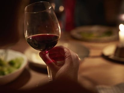 Una imagen de una mujer tomando una copa de vino.