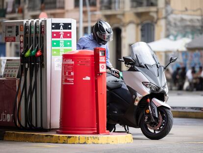 Un hombre reposta su moto en una gasolinera de Barcelona.
