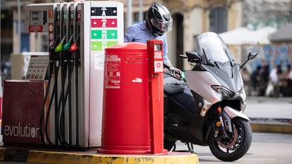 Un hombre reposta su moto en una gasolinera de Barcelona.