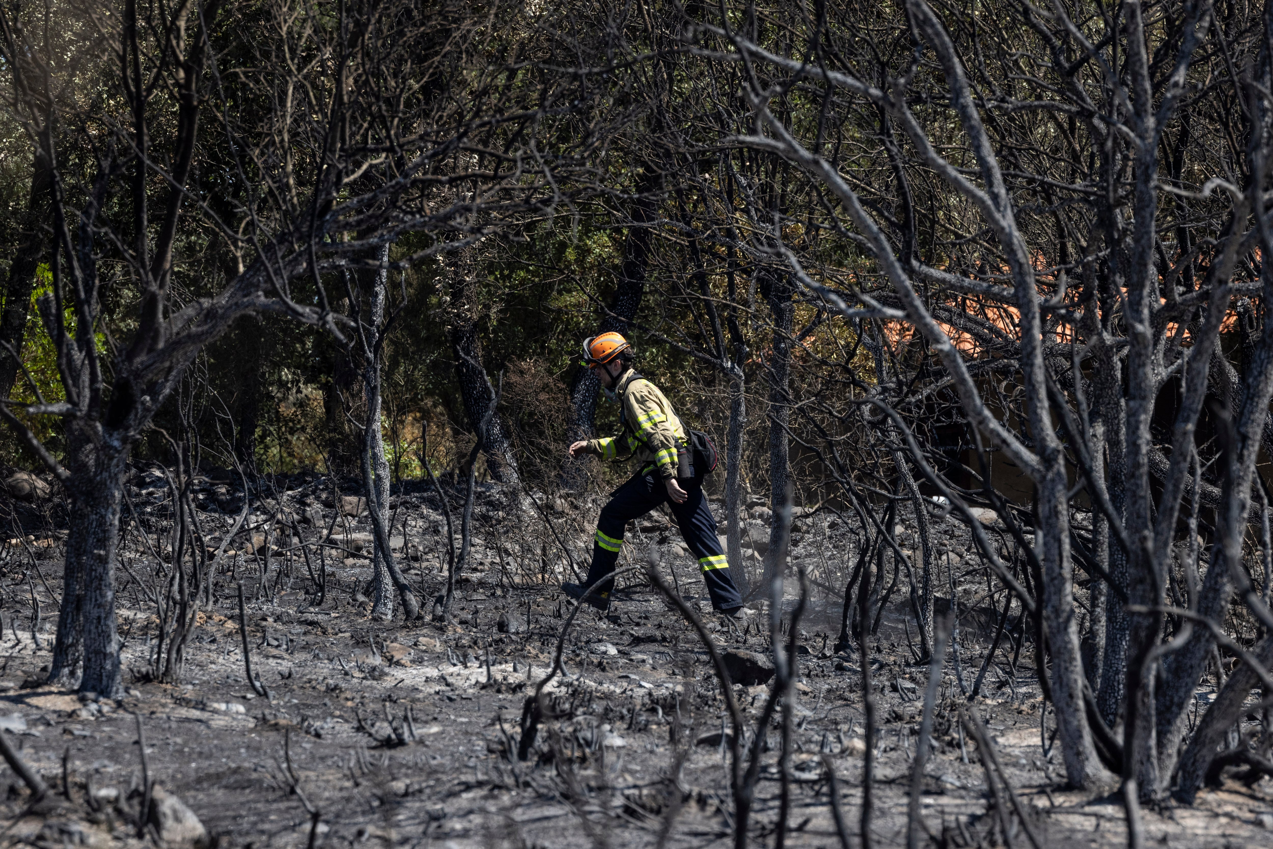 Un bombero en Cruïlles, este domingo por la mañana, donde todavía se encendía el bosque en Les Gavarres, en el término municipal de Cruïlles, Monells y Sant Sadurní de L'Heura.