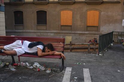 Un hombre duerme en un banco el segundo día de fiesta de los sanfermines, el 8 de julio de 2016.