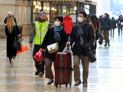 Turistas caminan en Milán, Italia, con mascarillas, este lunes.