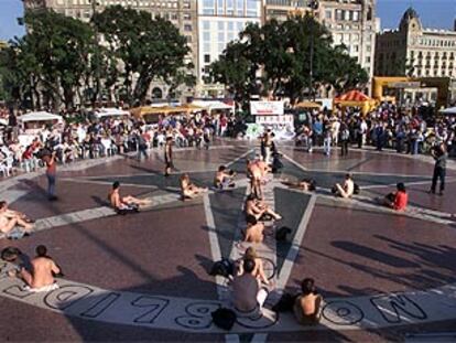 Una veintena de participantes formando el signo de la paz desnudos, ayer, en la plaza de Catalunya de Barcelona.