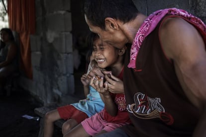 Lama abraza cariñosamente a su hija Kimberly, de ocho años, durante el desayuno. Su familia está compuesta por 10 miembros que viven en dos casas junto al sembrado. Manuel confiesa que tiene miedo a los tifones, pero que decidió quedarse en el campo, en lugar de trabajar en la capital, para poder criar a su familia.