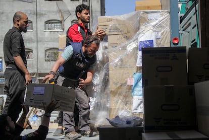 Varias personas descargan ayuda este sábado cerca del hospital Kamal Adwan, en el norte de Gaza.