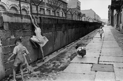 Durante la construcción del Muro, los niños jugaban alrededor de sus fronteras. En la imagen se observa a una niña intentando subir la pared.