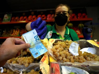 Un hombre comprando en el mercado de la plaza de Lugo de A Coruña.