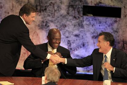 Rick Perry (izquierda) saluda a Mitt Romney en presencia de Herman Cain en el debate del martes.