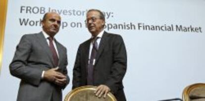 El ministro de Economía, Luis de Guindos, acompañado por el director general del Fondo de Reestructuración Ordenada Bancaria (FROB), Antonio Carrascosa