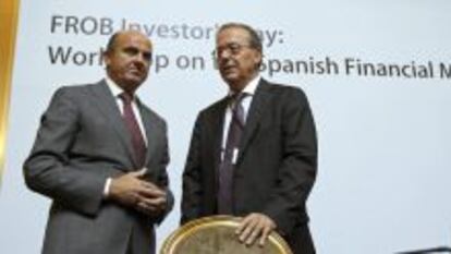 El ministro de Econom&iacute;a, Luis de Guindos, acompa&ntilde;ado por el director general del Fondo de Reestructuraci&oacute;n Ordenada Bancaria (FROB), Antonio Carrascosa