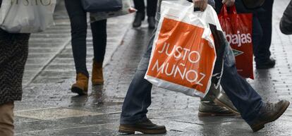 Un grupo de personas camina con bolsas de diversos establecimientos el primer d&iacute;a de rebajas en Valladolid.