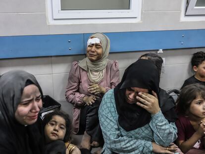 Mujeres y niños en el hospital Al Ahli tras el bombardeo que mató a cientos de personas en el recinto del centro médico, este martes.