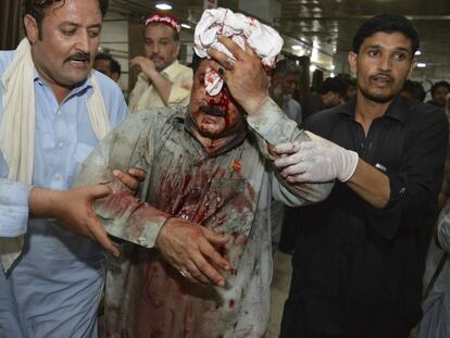 Voluntarios ayudan a una de las personas heridas este martes en Peshawar (Pakistán).