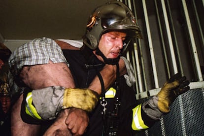 Un bombero evacua a una de las víctimas del incendio.