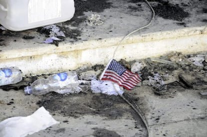 Una banderita estadounidense permanece en el suelo frente a restos carbonizados en el edificio del consulado estadounidense en Bengasi (Libia)