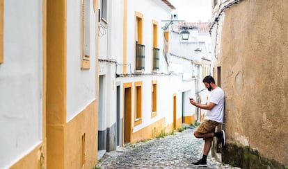 Un joven mirando su teléfono móvil en un pueblo.