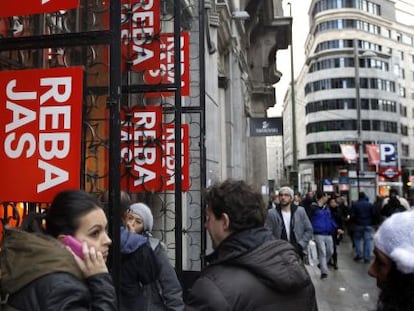 Varias personas ante un comercio en rebajas en la Gran V&iacute;a de Madrid.