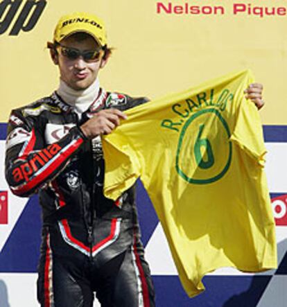Pedrosa, en el podio, mostrando la camiseta que le regaló Roberto Ca
rlos.