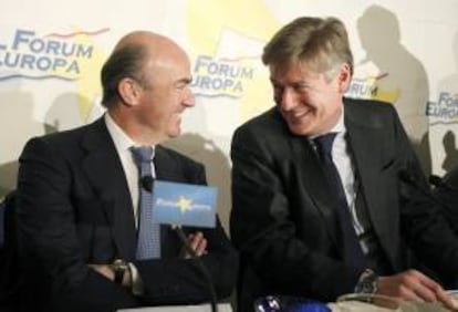 El ministro de Economía, Luis de Guindos, junto al eurodiputado del PP Antonio López-Istúriz (d), durante un desayuno organizado hoy por Nueva Economía.