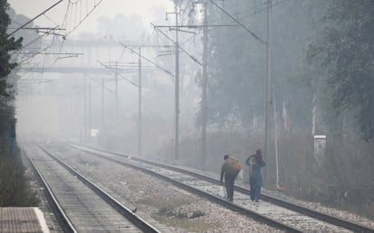 Residentes indios caminan entre una fuerte contaminación cerca de la estación de tren Lodhi, en Nueva Delhi (India).