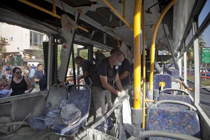La policía israelí examinando los restos dentro del autobús.